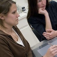 Two female college students work at a computer