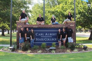 students in front of entrance sign 