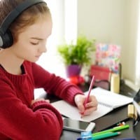 Preteen girl working on homework using tablet