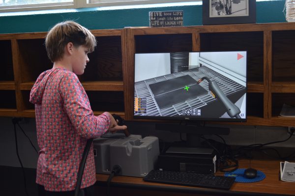 A boy playing a virtual welding game