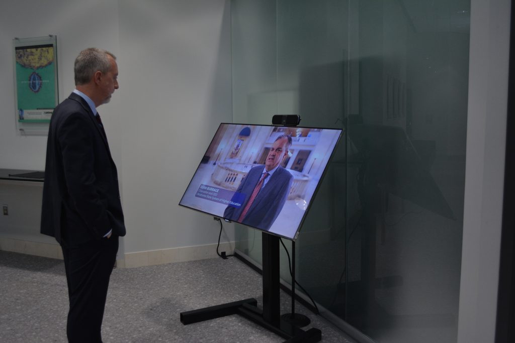 John Hennessey watching reception video on small monitor